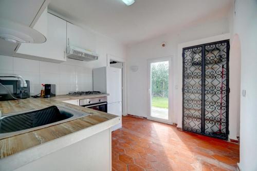 a kitchen with a sink and a door to a yard at Murches' House in Alcabideche