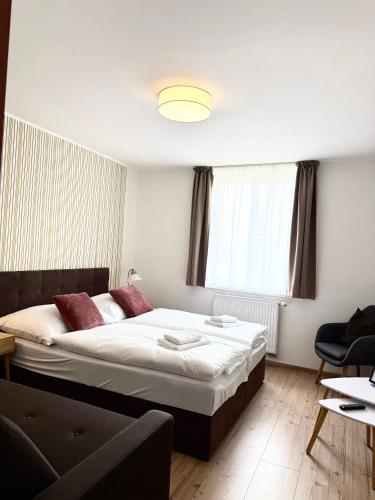 a bedroom with a large bed and a couch at Penzion Raimund in Smokovce