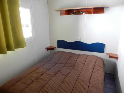 une chambre avec un lit dans une pièce avec une fenêtre dans l'établissement Camping 3 étoiles - ccbb0fe, à Tallard