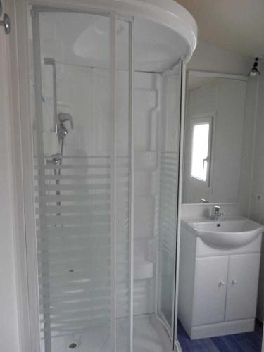 une salle de bain blanche avec une douche et un lavabo dans l'établissement Camping 3 étoiles - ccbb0fe, à Tallard