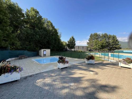 un patio avec trois plantes en pot et une piscine dans l'établissement Camping 3 étoiles - ccbb0fe, à Tallard