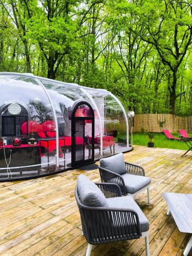 - un kiosque avec des chaises et des tables sur une terrasse en bois dans l'établissement Bulle Love Passion & Spa, à Escamps