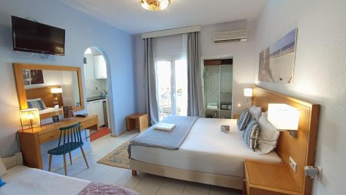 a hotel room with a bed and a desk and a bedroom at Villa Riviera in Stavros