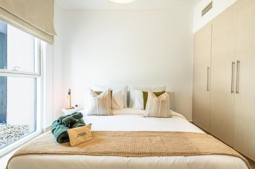 a bedroom with a large bed with a large window at Cozy Retreat At Waters Edge, By Voyage in Yas Island