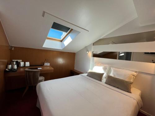 a bedroom with a bed and a desk and a window at Maison LUTETIA R in Strasbourg