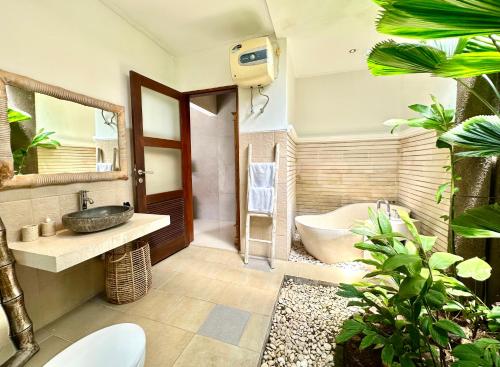 a bathroom with a tub and a sink and a bath tub at Villa Searenity Seminyak in Seminyak