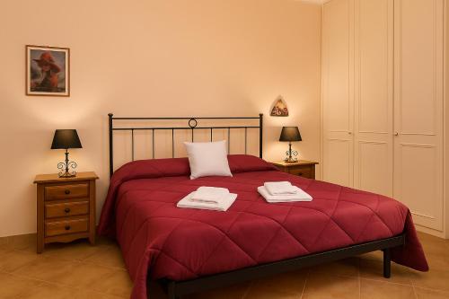 a bedroom with a red bed with two towels on it at Villa Fabi in Brindisi