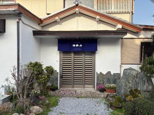 a house with a blue awning on the front of it at OceanフロントYASHIRO鴨川 目の前に海が広がる広々一軒家貸切 11名 in Kamogawa