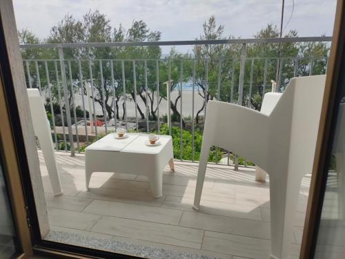 a white table and chairs on a balcony at Comfort in riva al mare in Belmonte Calabro