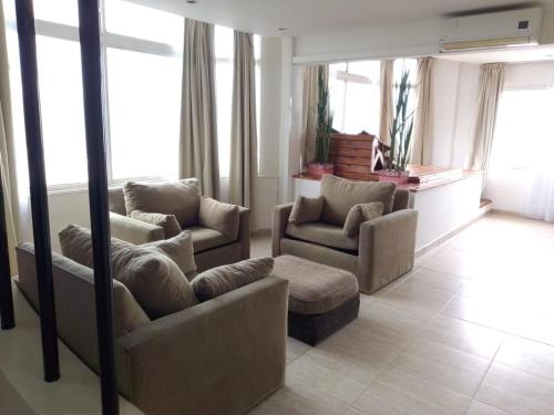 a living room with two chairs and a couch at Hotel Golf Internacional in Santa Teresita