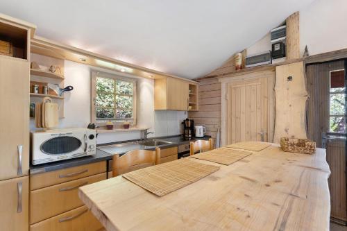 a kitchen with a wooden table and a microwave at Blockhütte in Langewahl