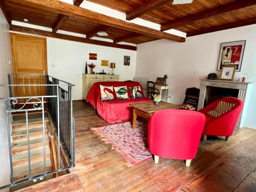 - un salon avec un lit rouge et une table dans l'établissement Maison de village Da Margot, à Lozzi