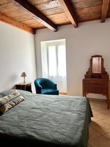 une chambre avec un lit et une chaise bleue dans l'établissement Maison de village Da Margot, à Lozzi