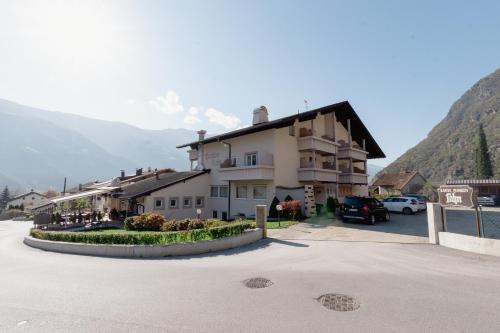 a building in a parking lot next to a mountain at Pension Lahn in Rablà