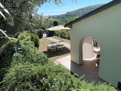 a house with a patio with a table and chairs at Casa Rosmarino, grill, Wi-Fi by ToscanaTour in Riparbella