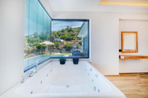 a large white bath tub in a room with a window at Villa Zero in Fethiye