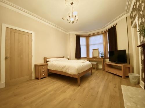 a bedroom with a bed and a flat screen tv at Inverness Holiday House in Dalneigh