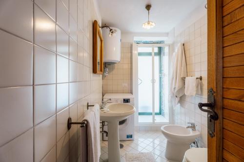 Un baño blanco con lavabo e inodoro. en Casa Valeria in the countryside, en SantʼAgata sui Due Golfi