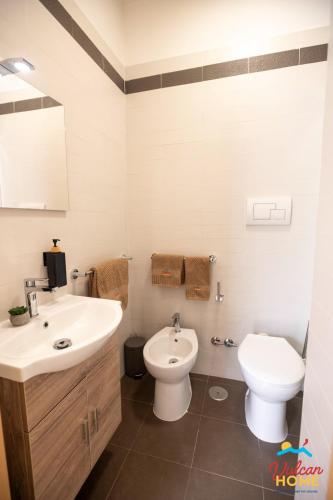 a bathroom with a white sink and a toilet at VulcanHome in Cercola