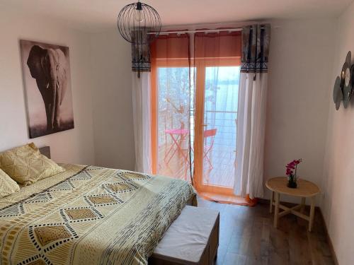 une chambre avec un lit, une fenêtre et une table dans l'établissement Les Brises, à Saint-Gingolph