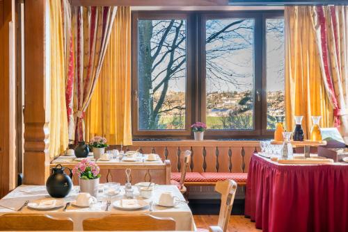 een eetkamer met tafels en stoelen en ramen bij Hotel-Gasthof Huber in Ebersberg