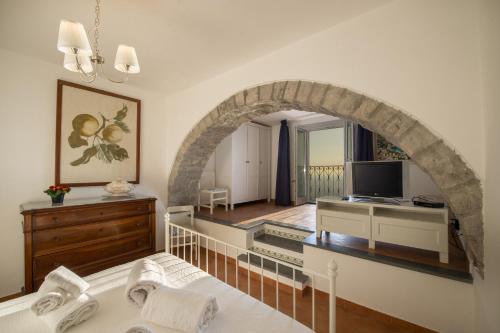 a living room with an archway and a television at Villa Cimino - for walking lovers! in Praiano