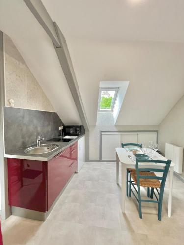 une cuisine avec un évier et une table avec des chaises dans l'établissement Pause cosy - Châteauroux Centre, à Châteauroux