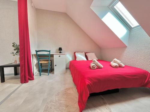 - une chambre dotée d'un lit rouge avec deux ours en peluche dans l'établissement Pause cosy - Châteauroux Centre, à Châteauroux