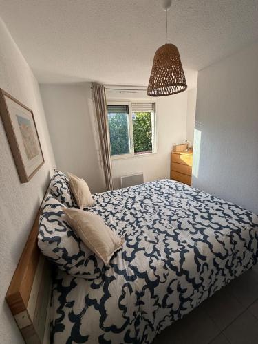 une chambre avec un lit avec une couette bleue et blanche dans l'établissement Charmant appartement moderne avec place de parking privative, à Marseille