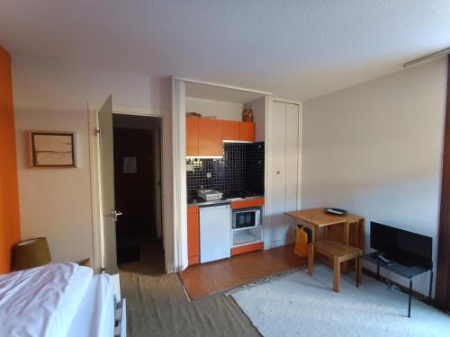 Cette chambre comprend une cuisine avec un lit et une table. dans l'établissement Studio pour 2 pers à Montgenèvre - Proximité pistes et commerces - Parking inclus - Petit Budget - FR-1-445-154, à Montgenèvre