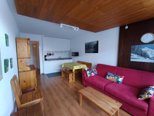 un salon avec un canapé rouge et une table dans l'établissement Appartement proche pistes et commerces, 6 pers, vue montagnes, animaux admis, parking - FR-1-445-86, à Montgenèvre