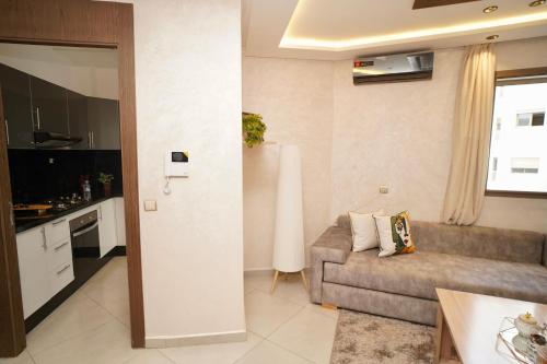 a living room with a couch and a kitchen at Un Stay Magique vous attend à Kenitra in Kenitra