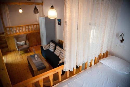 a bedroom with a bed and a couch and a table at The Water Mill Cottage in Lagoúdi Zía