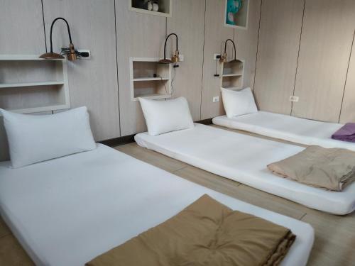 three beds sitting in a room with shelves at Checheng Backpackers Hostel in Checheng