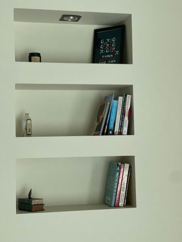 two shelves with books and a clock on them at Entire apartment in Gulshan area in Ayubnagar