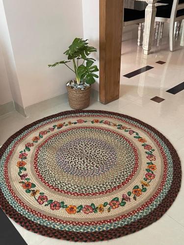 a circular rug on a floor with a potted plant at Entire apartment in Gulshan area in Ayubnagar
