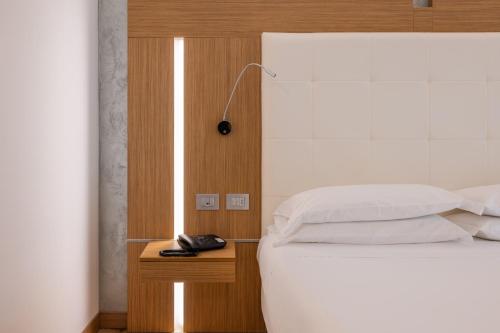 a bedroom with a white bed and a night stand with a lamp at Kriss Internazionale Hotel in Bardolino
