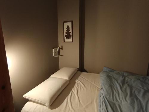 - une chambre dotée d'un lit avec des draps blancs dans l'établissement Studio cosy avec terrasse, jardin, proche pistes et commerces à Montgenèvre - FR-1-445-188, à Montgenèvre