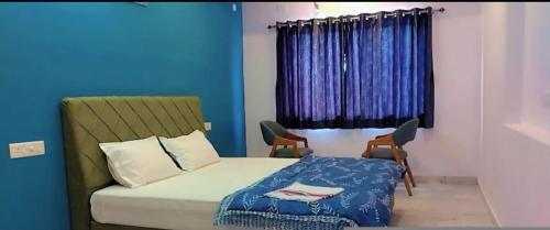 a bedroom with a bed and a blue wall at The prem bag hotel debari Udaipur in Debāri