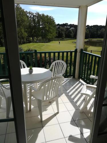a patio with a table and chairs and a golf course at Flat 4 person on golf view in Talmont