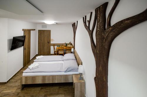 a bedroom with a tree on the wall at Scarlett Pension & Restaurant in Veľký Meder