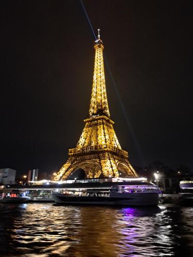 a view of the eiffel tower at night at Maison familiale Ecole des Filles in Ully-Saint-Georges