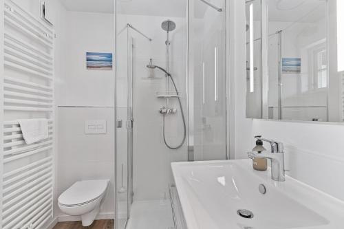 a white bathroom with a shower and a toilet at Beach Lodge Beach Lodge Appartement 2 in Böhl