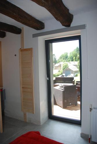 a room with a sliding glass door with a balcony at B&B Le Courtil in Dohan