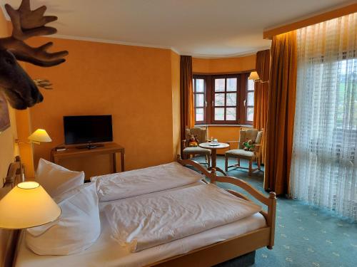Un dormitorio con una cama y una sala de estar. en Hotel Hirsch, en Rothenberg