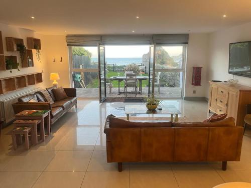 a living room with a couch and a table at Large Stunning Sea View Coastal Townhouse in Killough