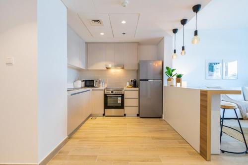 a kitchen with stainless steel appliances and a wooden floor at Voyage's Elegant 1br In Waters Edge in Abu Dhabi