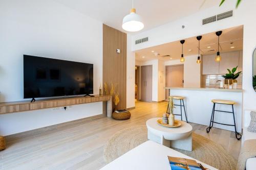 a living room with a large flat screen tv on a wall at Voyage's Elegant 1br In Waters Edge in Abu Dhabi
