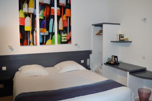a bedroom with a bed and a painting on the wall at Hotel La Marine, Vieux Port in La Rochelle