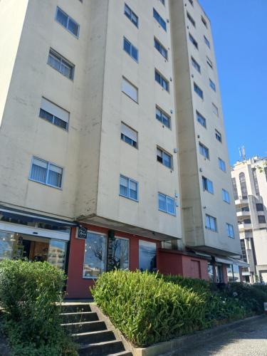 a tall white building with stairs in front of it at Praça da Cidade in Oliveira de Azemeis